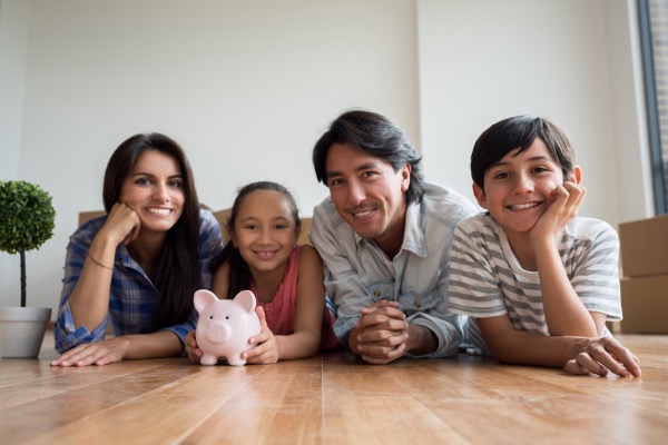 Family laying on the floor with piggy bank